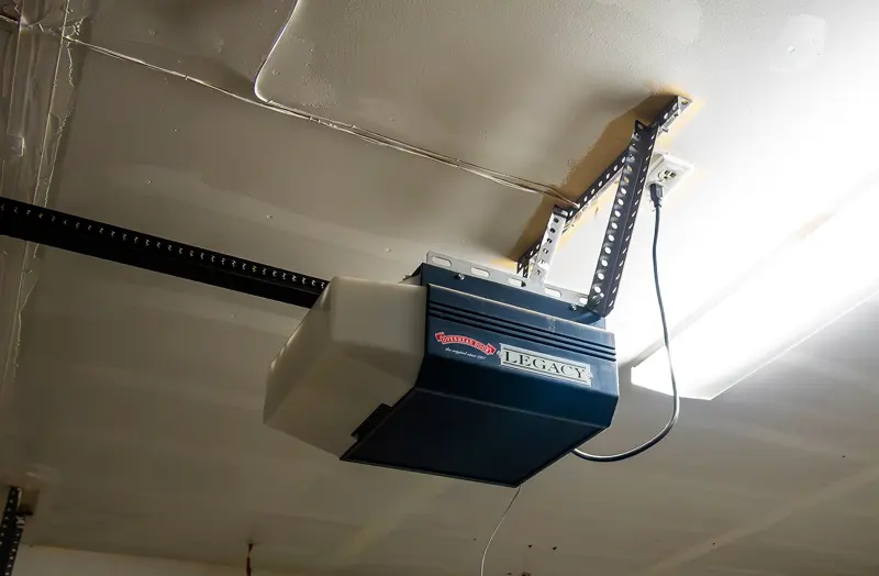 Ceiling-mounted garage door opener unit with its rail